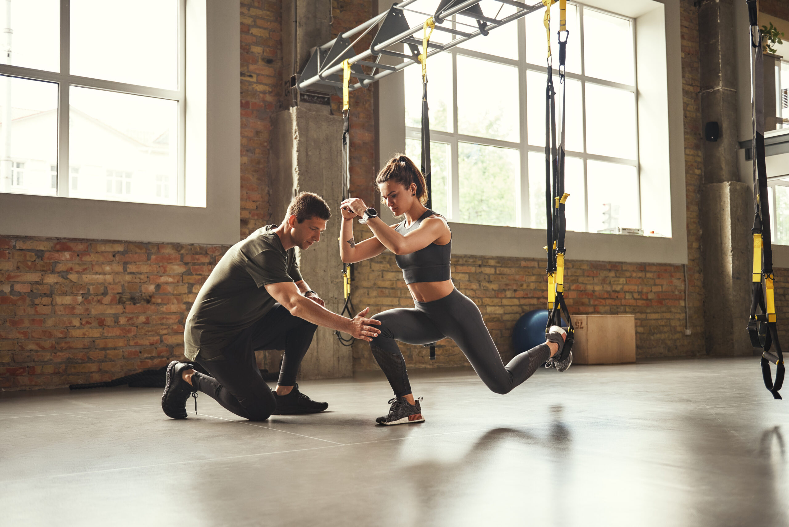 Doing,Squat,Exercise.,Confident,Young,Personal,Trainer,Is,Showing,Slim